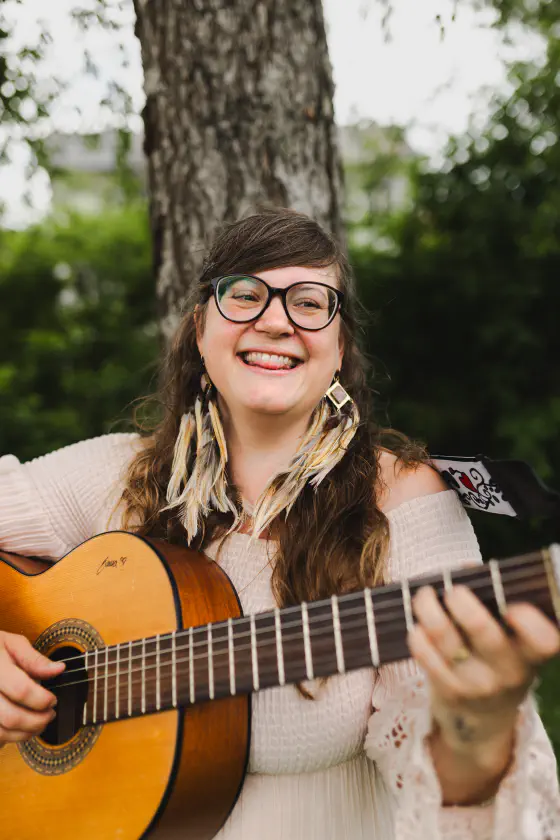 Emma är glad och spelar gitarr