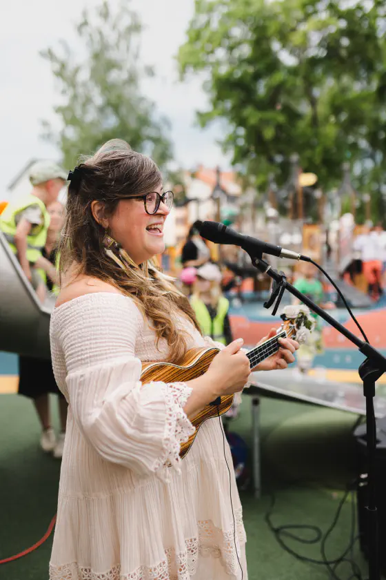 Emma spelar ukulele vid invigningen av en lekpark i Östhammar